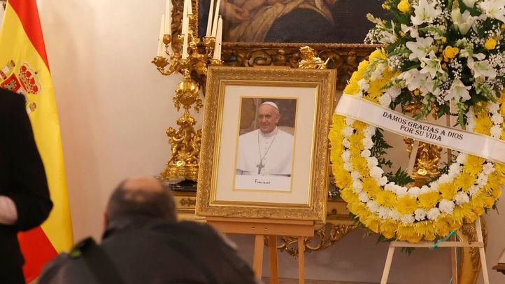 Altar junto a un libro de condolencias abierto por el fallecimiento del Papa Francisco I, junto a un retrato del Papa y una corona de flores, en la Nunciatura Apostólica, a 22 de abril de 2025, en Madrid