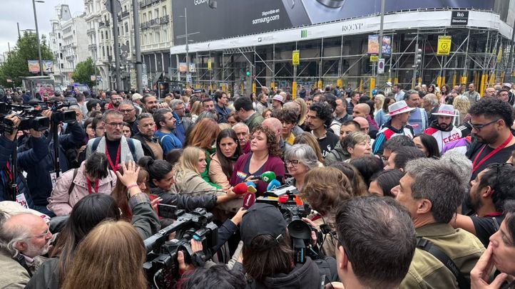 Los periodistas se arremolinan alrededor de los representantes sindicales en medio de la calle antes de la marcha del 1 de mayo