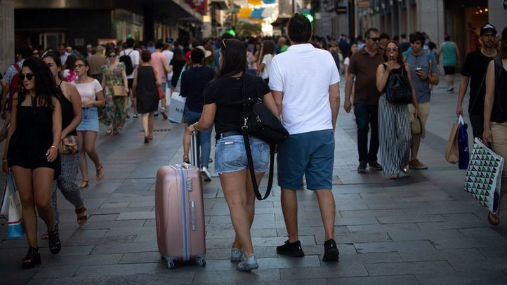 Turistas con maletas, posibles usuarios de pisos turísticos en el centro de Madrid.