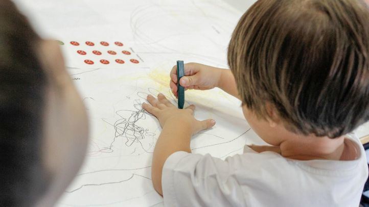 Un niño pinta en la mesa en la clase de Educación Infantil.