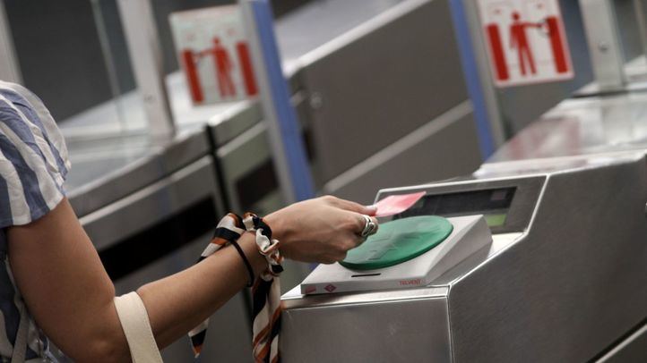 Una mujer pasa su billete en el torno del Metro Plaza de España