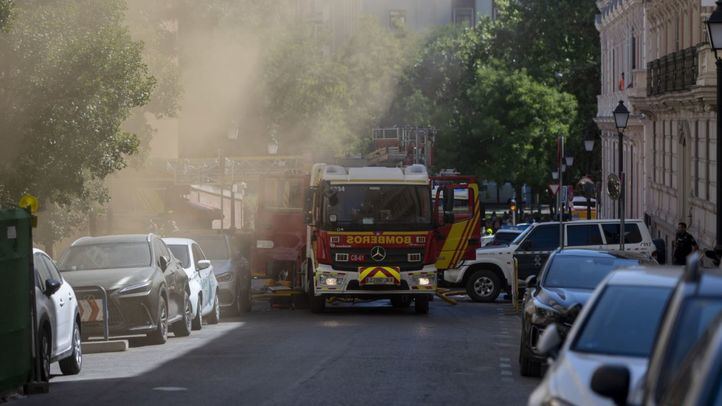 Un camión de bomberos entre el humo procedente del incendio