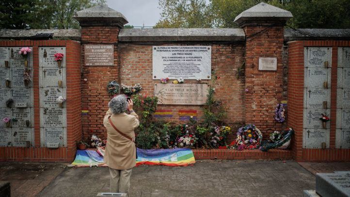 Una mujer fotografía la placa conmemorativa de las Trece Rosas durante un homenaje a las víctimas del franquismo, en la tapia de las Trece Rosas