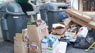 Contenedores de basura llenos de cartón en el suelo