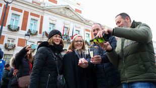 Varias personas celebran con bebida las Preuvas en la Puerta del Sol, a 30 de diciembre de 2022