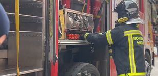 Los bomberos intervienen en el incendio de un coche en un garaje de Carabanchel