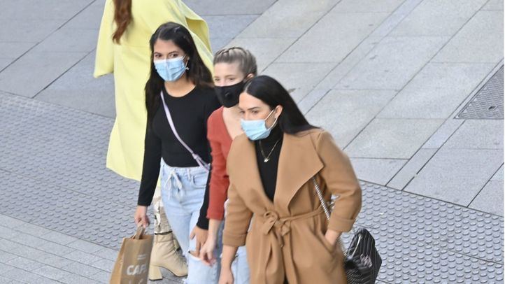 Tres jóvenes caminan por la Gran Vía con mascarilla, en una imagen de archivo