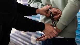 Imagen de archivo de un agente esposando a un detenido