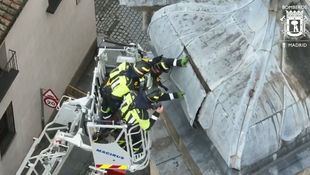 Bomberos sujetan una plancha desprendida de la Basílica de San Miguel en Madrid