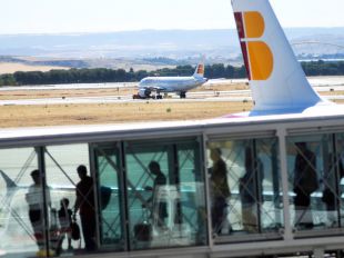 pasajeros aeropuerto Barajas en un finger para embarcar en Iberia y al fondo la pista 