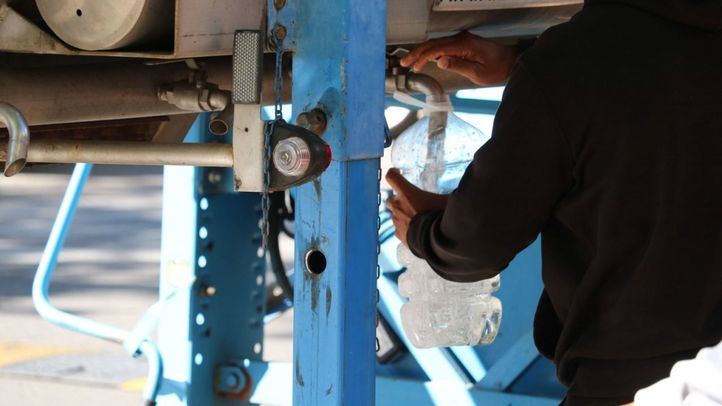 Una persona rellena una garrafa de agua en Alcalá durante el corte del suministro
