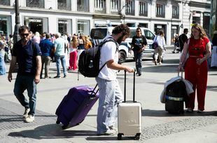 Turista con maletas en la Puerta del Sol.