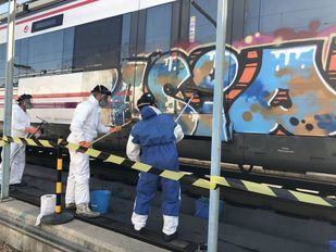 Archivo: Operarios limpian un grafiti en un tren de Cercanías de Madrid, en una foto de archivo