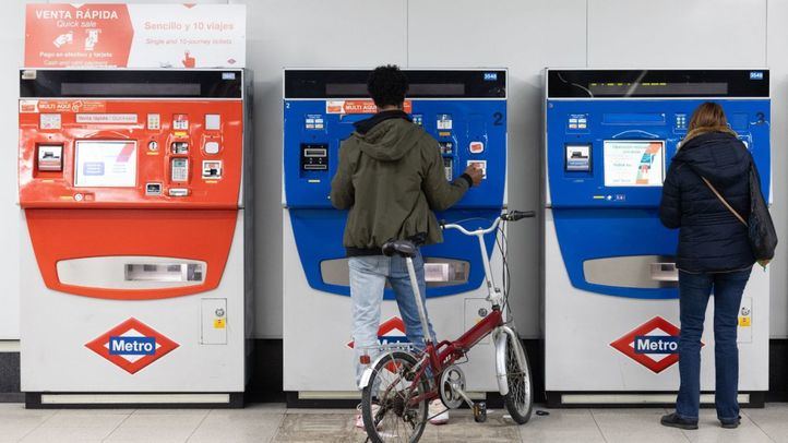 Varias personas compran billetes en una estación de Metro de Móstoles Central.