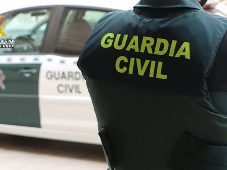 Un agente de la Guardia Civil junto a un vehículo oficial.