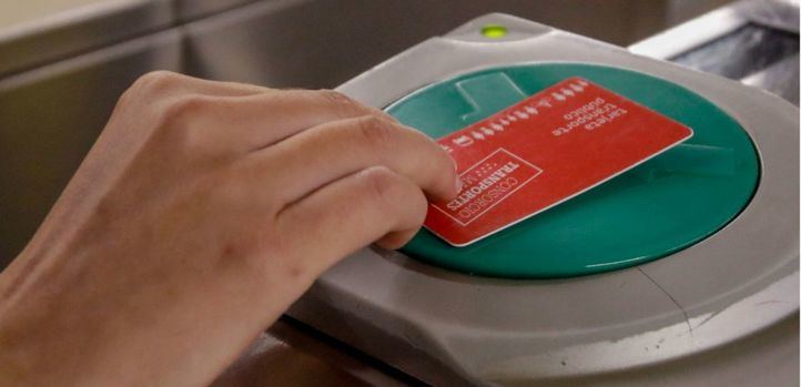 Una persona valida su abono en los tornos de entrada del metro