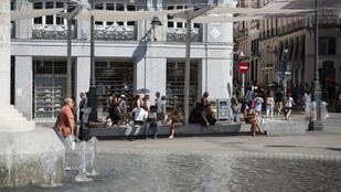 Turistas evitando el calor en la Puerta del Sol