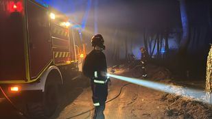 Bomberos y agentes forestales trabajan para perimetrar el incendio en Lozoyuela, que sigue activo