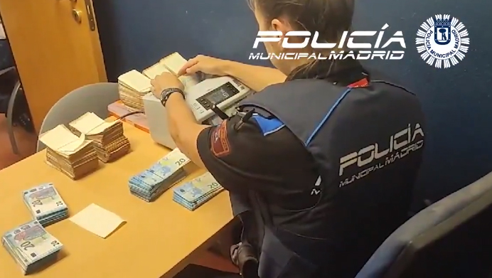 Una agente de la Policía Municipal cuenta los miles de euros intervenidos en un coche en Madrid