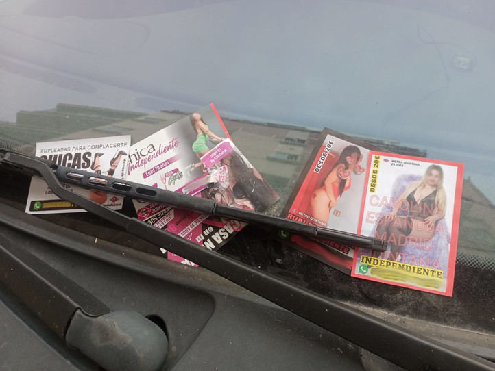 Anuncios de prostitución en el parabrisas de un coche