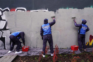 Grafiteros limpian pintadas de un muro en Tetuán para conmutar su sanción