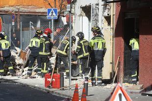 Bomberos trabajan en el desescombro del local que explotó en Puente de Vallecas