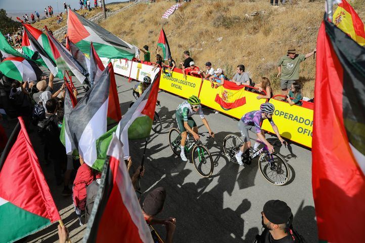 Varios ciclistas pasan por una zona con protestas propalestinas durante la 20ª etapa de la Vuelta Ciclista a España, a 13 de septiembre de 2025, en Navacerrada, Madrid (España)