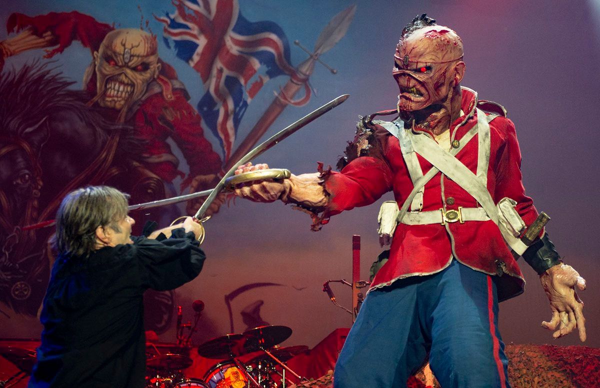 El cantante, Bruce Dickinson, se bate en duelo contra Eddie, la mascota del grupo. [Twitter @IronMaiden]