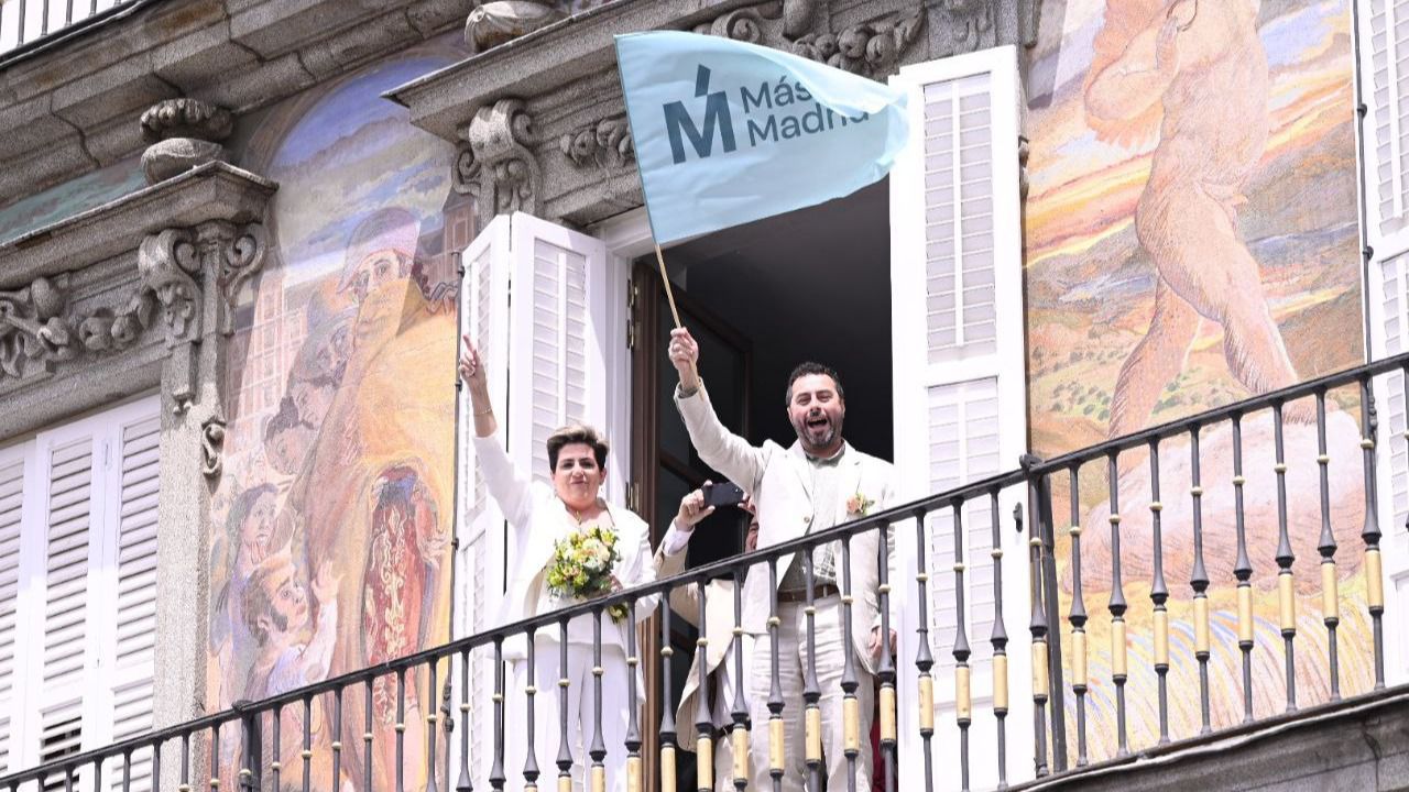 Una pareja de novios ondea la bandera de Más Madrid durante el mitin (Foto: Chema Barroso)