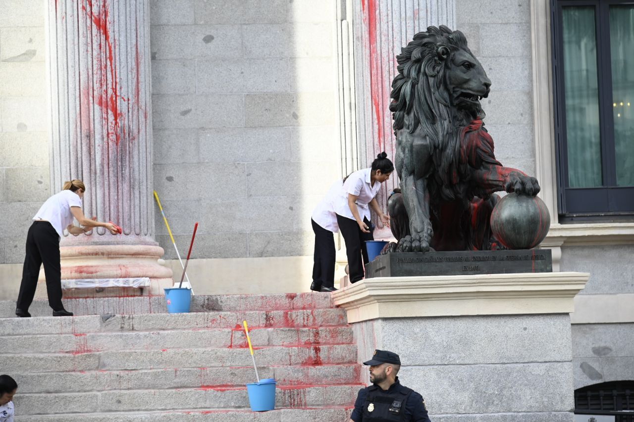 Limpieza de la puerta del Congreso después de que los activistas climáticos lanzaran pintura roja (Foto: Chema Barroso)