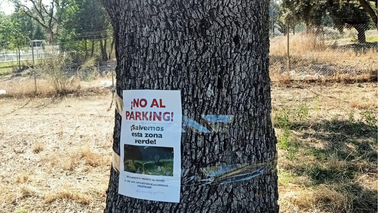 Cartel de protesta de los vecinos en una de las encinas afectadas