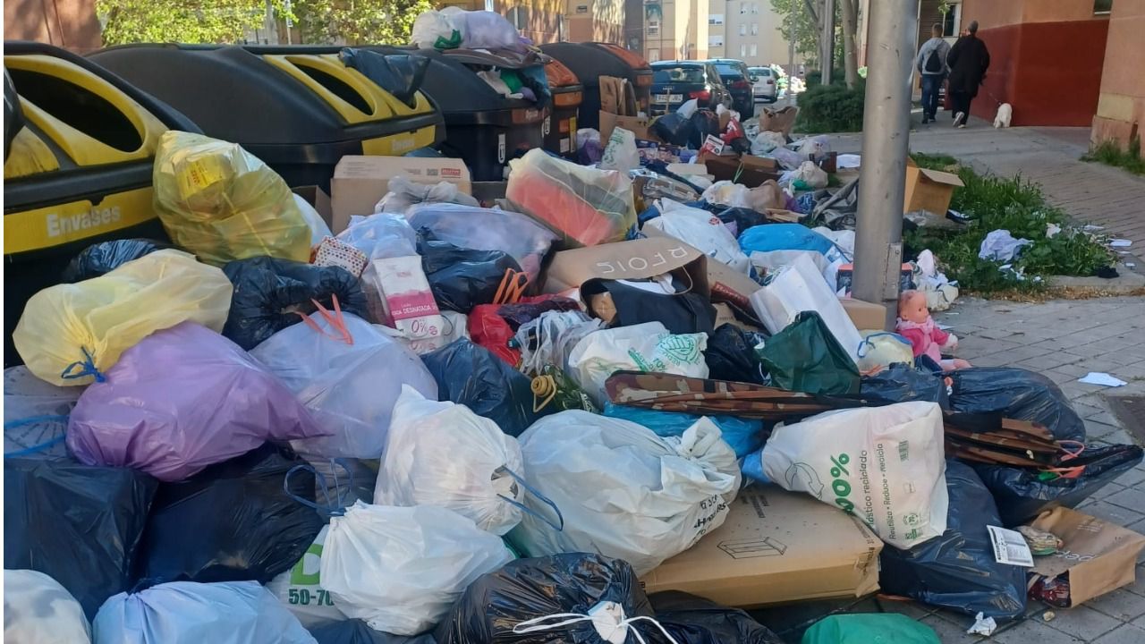 Bolsas de basura fuera de los contenedores por desbordamiento.