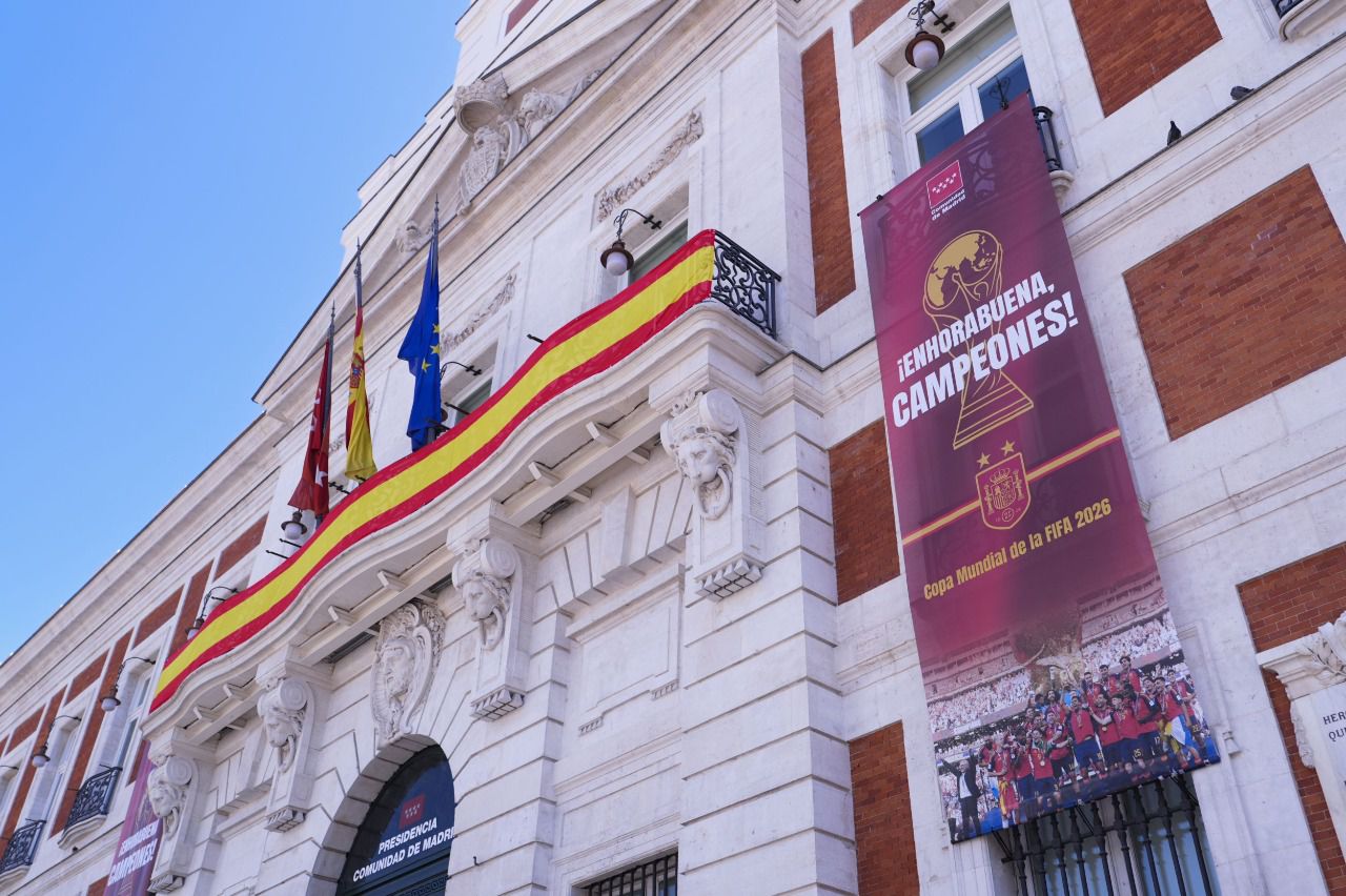 Real Casa de Correos con una bandera española y las lonas conmemorativas (Foto. Comunidad de Madrid)