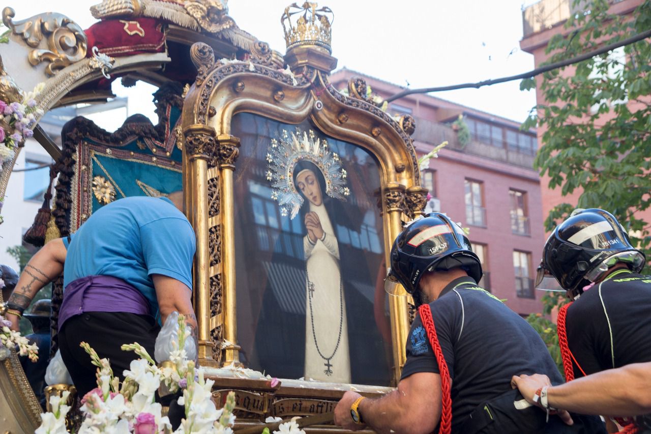 Bomberos junto a la Virgen de la Paloma durante la procesión.